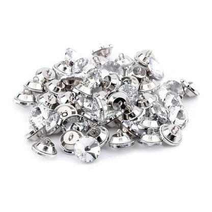 Botón acrílico BTN0620, 20 mm., 50 unds.-BOTONES-Botones de Tapicería de Cristal con Engarce Metálico Eleva la estética de tus muebles tapizados con estos exquisitos botones de cristal. Diseñados para añadir un toque de lujo y sofisticación, estos botones cuentan con un cristal facetado que captura y refleja la luz, creando un efecto brillante y llamativo. Cada botón está engarzado en una base metálica. La parte trasera del botón incorpora un asa metálica, facilitando su fijación en la tapicería y garantiza