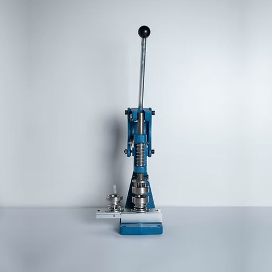 Prensa manual para presión controlada en trabajos de tapicería, específicamente para la colocación de botones forrados y otros elementos de fijación.ZM MHDD