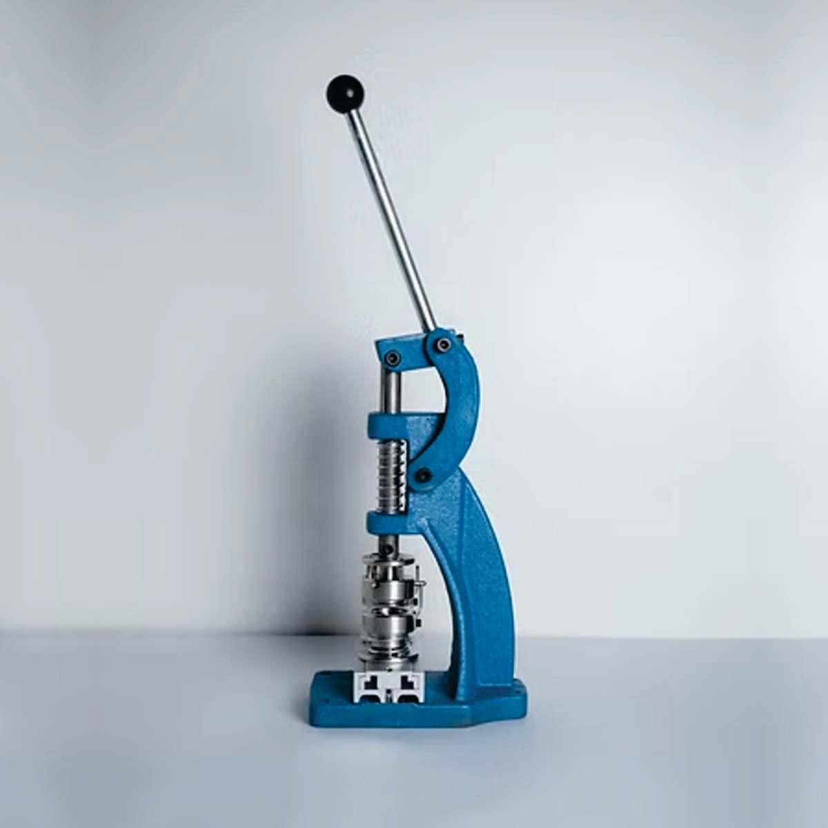 Prensa manual para presión controlada en trabajos de tapicería, específicamente para la colocación de botones forrados y otros elementos de fijación.ZM MHDD